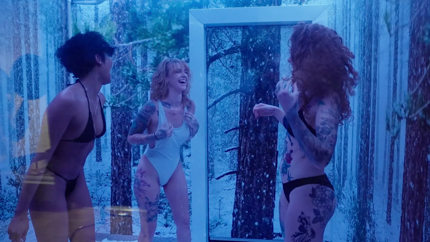 Guests laughing inside the blue-lit snow room in the finished Cleopatra's Rituals commercial.