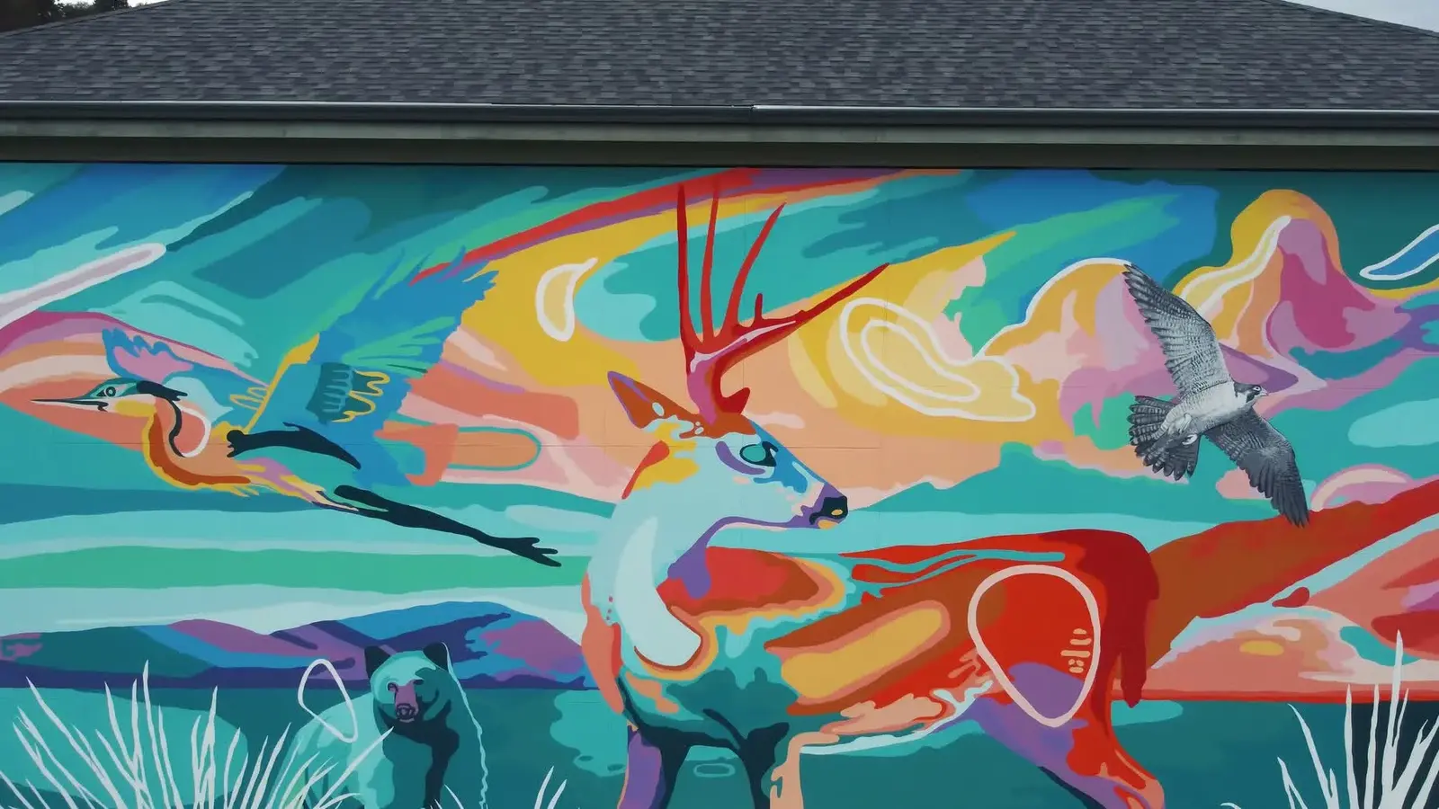 The finished Gratitude mural covers the wall of Winfield Memorial Hall with colourful Okanagan wildlife and landscape.