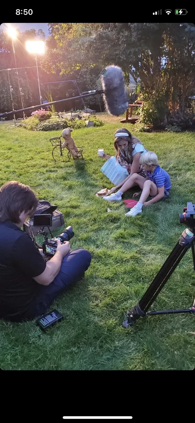 Camera setup near young Dave and young Connie on the grass during Three Hearts.